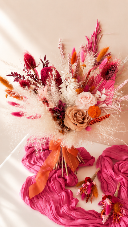 Bouquet of flowers with pink and orange accents on a white surface