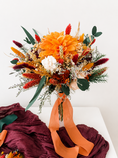 Handmade bridesmaid bouquet in burnt orange, burgundy and ivory preserved flowers with eucalyptus and dried grasses.