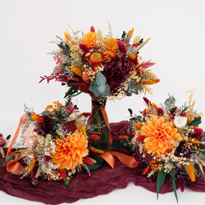 Autumn burnt orange and burgundy dried flower wedding collection including bridal bouquet, two bridesmaid bouquets and matching boutonnières.