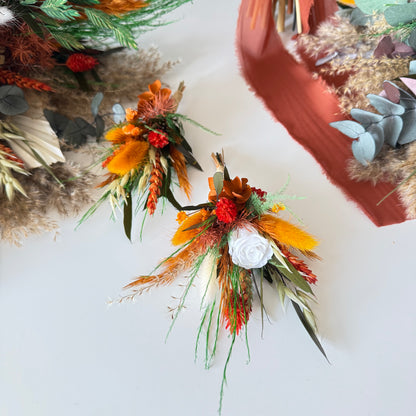 Detail shot of a rustic dried boutonniere with  roses, textured grasses, eucalyptus and natural preserved flowers.