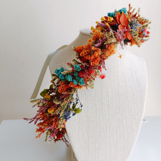 Bohemian floral headpiece made of preserved wildflowers in vivid rainbow hues, displayed on a mannequin