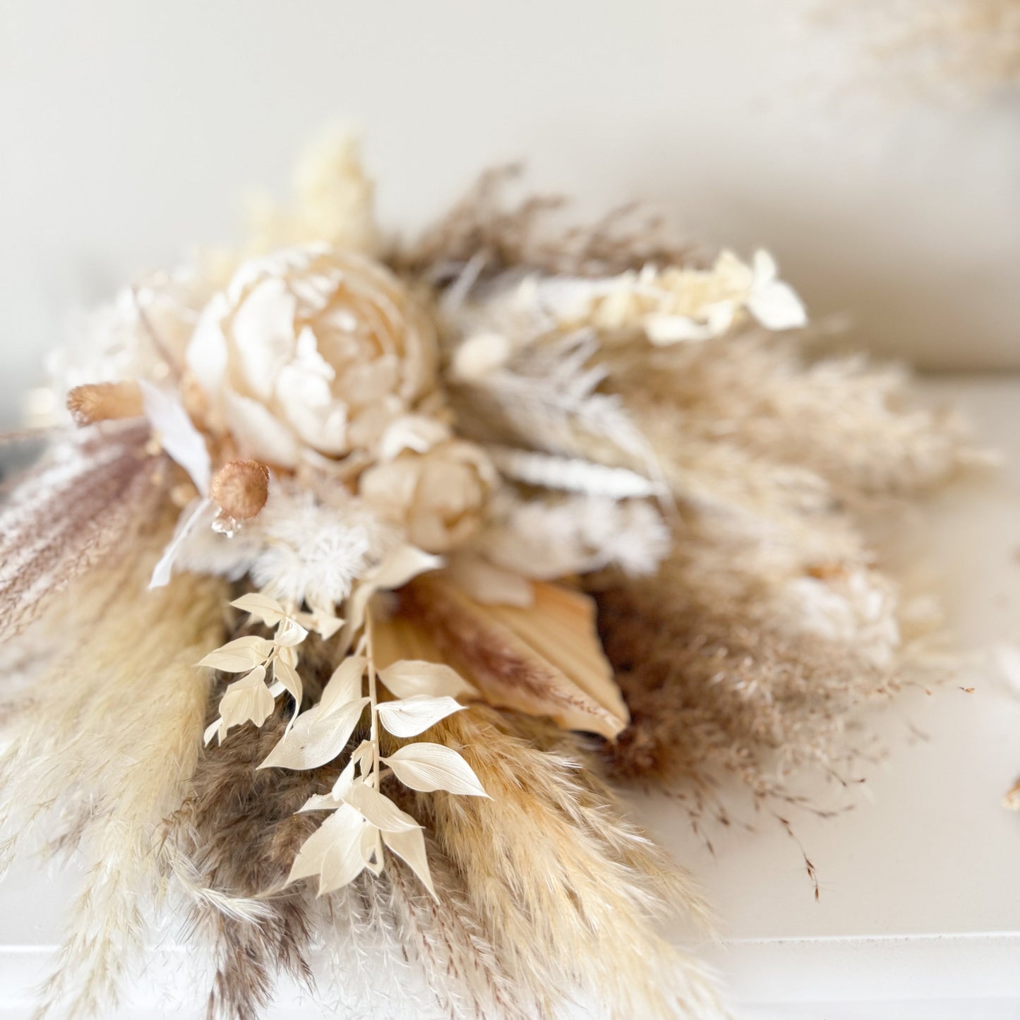 Boho-style BridesMaids bouquet featuring pampas grass and sola peonies in neutral shades for relaxed yet elegant ceremonies.