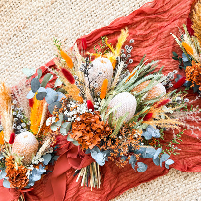 Boho wedding bouquet and matching arrangements featuring Australian native protea, pampas grass, and terracotta tones.