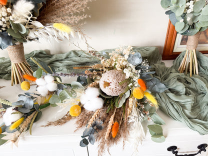 Bridesmaid dried flower bouquet in yellow and neutral tones featuring preserved eucalyptus, bunny tails, banksia and textured dried florals. Boho-style wedding bouquet with natural stems and yellow ribbon, perfect for rustic and modern weddings.