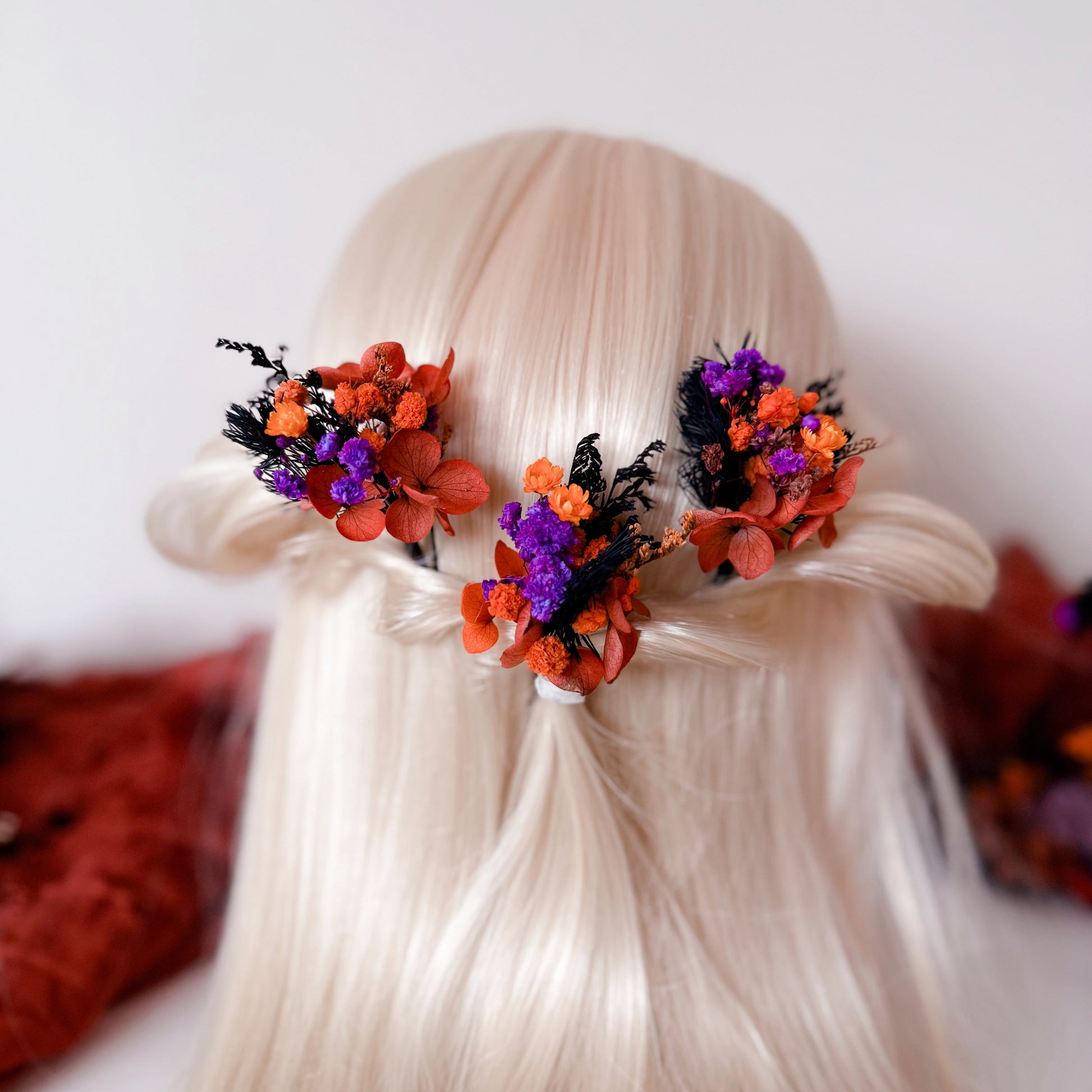 Bride hairstyle with two bright burnt orange and purple hair pins — boho wedding hairpiece made of preserved and dried flowers.