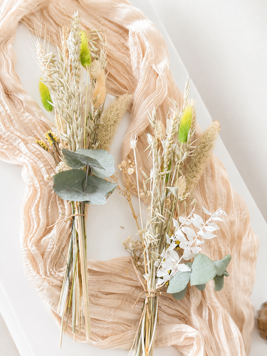 Handmade boho dried flower arrangement featuring natural grasses and preserved eucalyptus for home decor