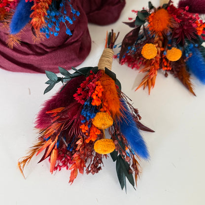 Colorful dried flower boutonniere with feathers on a white surface