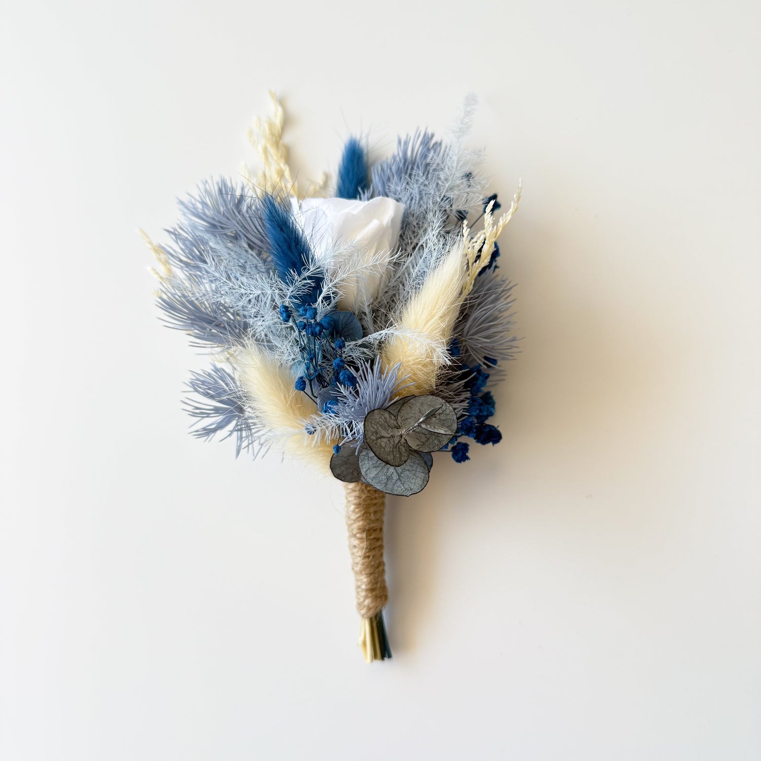 Dried flower bouquet with blue and beige tones on a white background