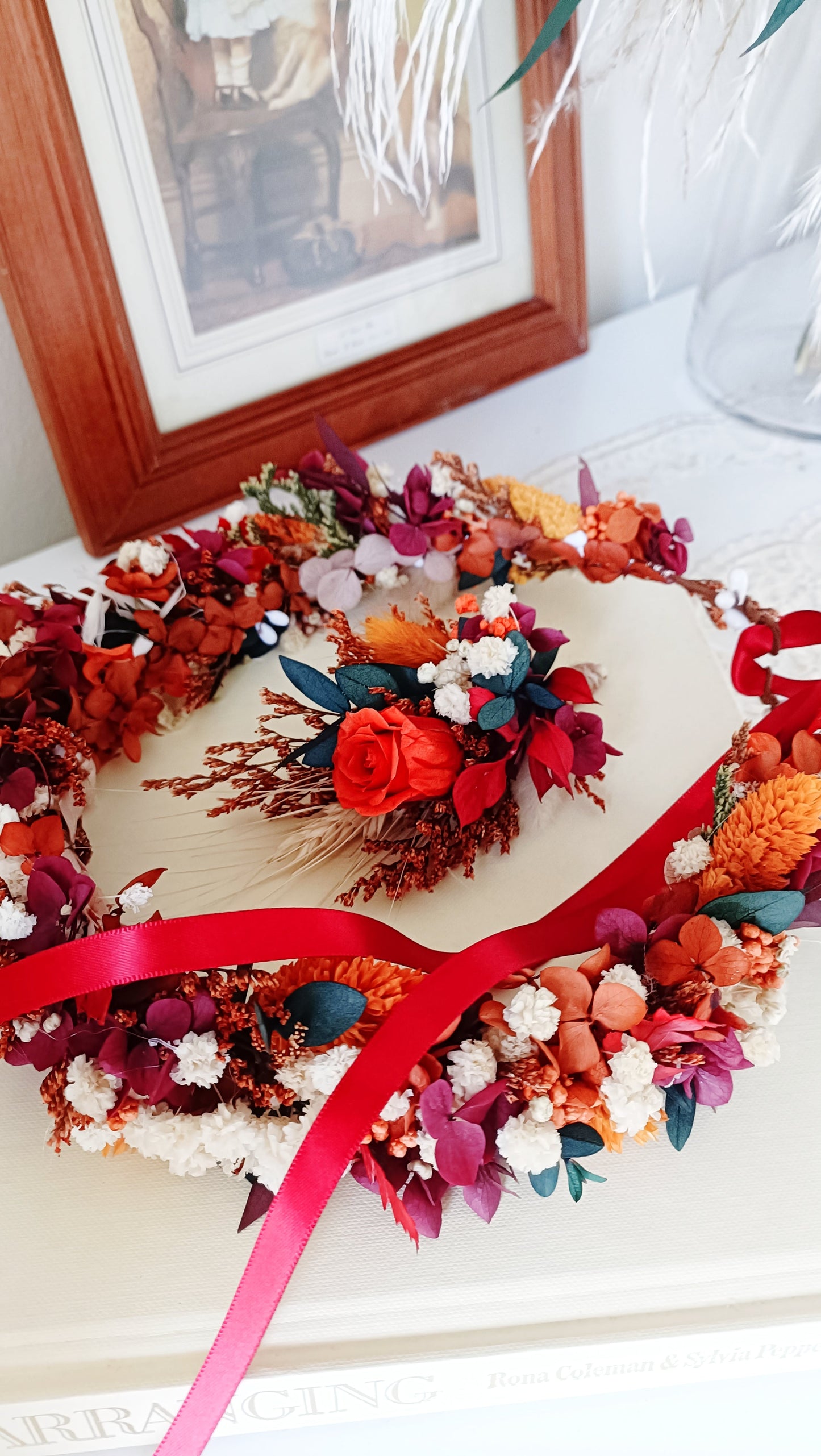 Flat wreath centerpiece made with red preserved roses, white sola flowers, and dried accents, styled with candles for romantic boho decor.