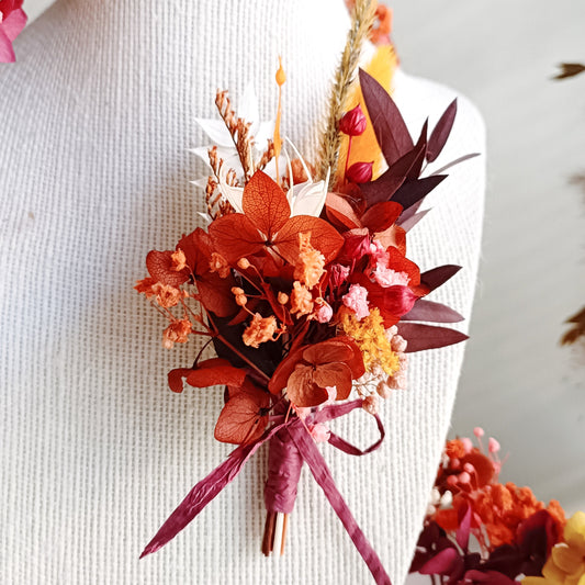 Boho-style boutonniere with dried flowers in shades of pink, red, and yellow, designed for brides, bridesmaids, or vintage-inspired looks. Unique, handmade floral hair accessories.