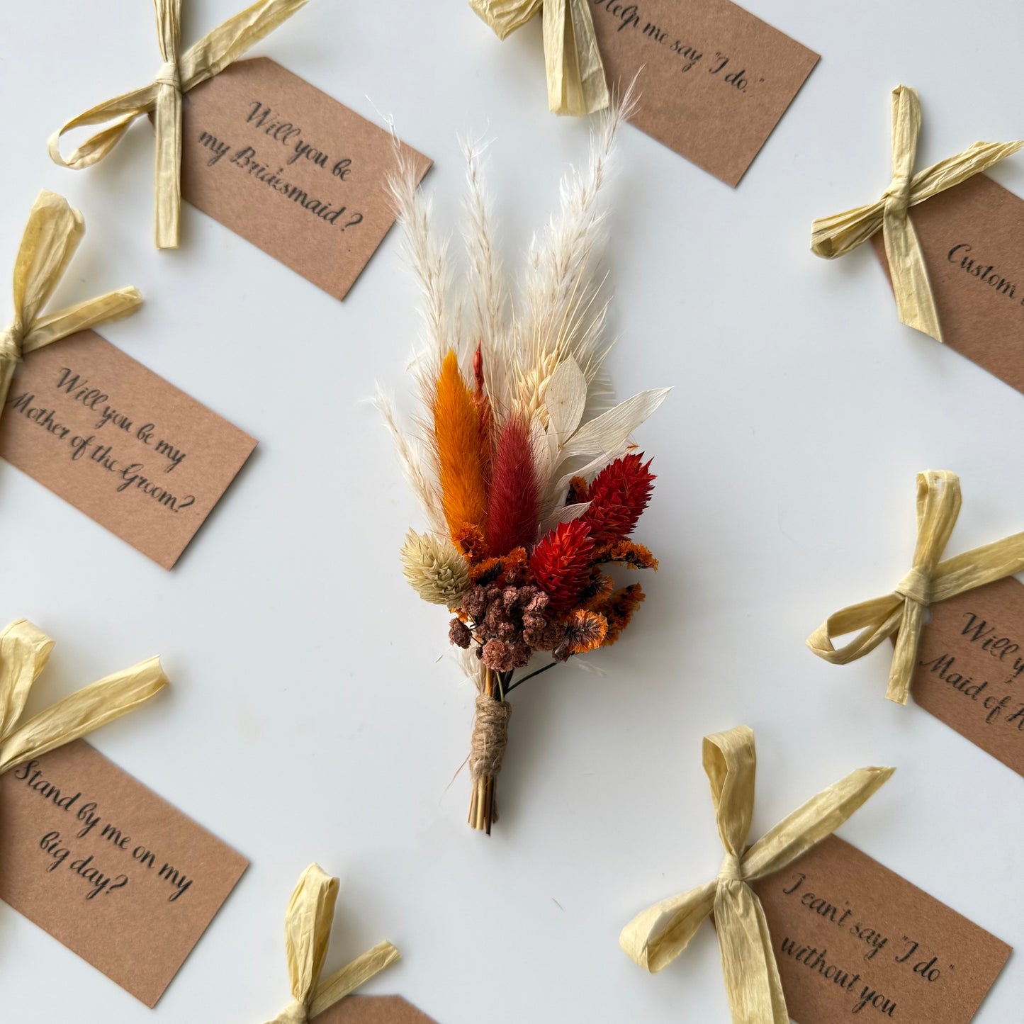 Dried flower boutonniere with wedding proposal tags on a white background