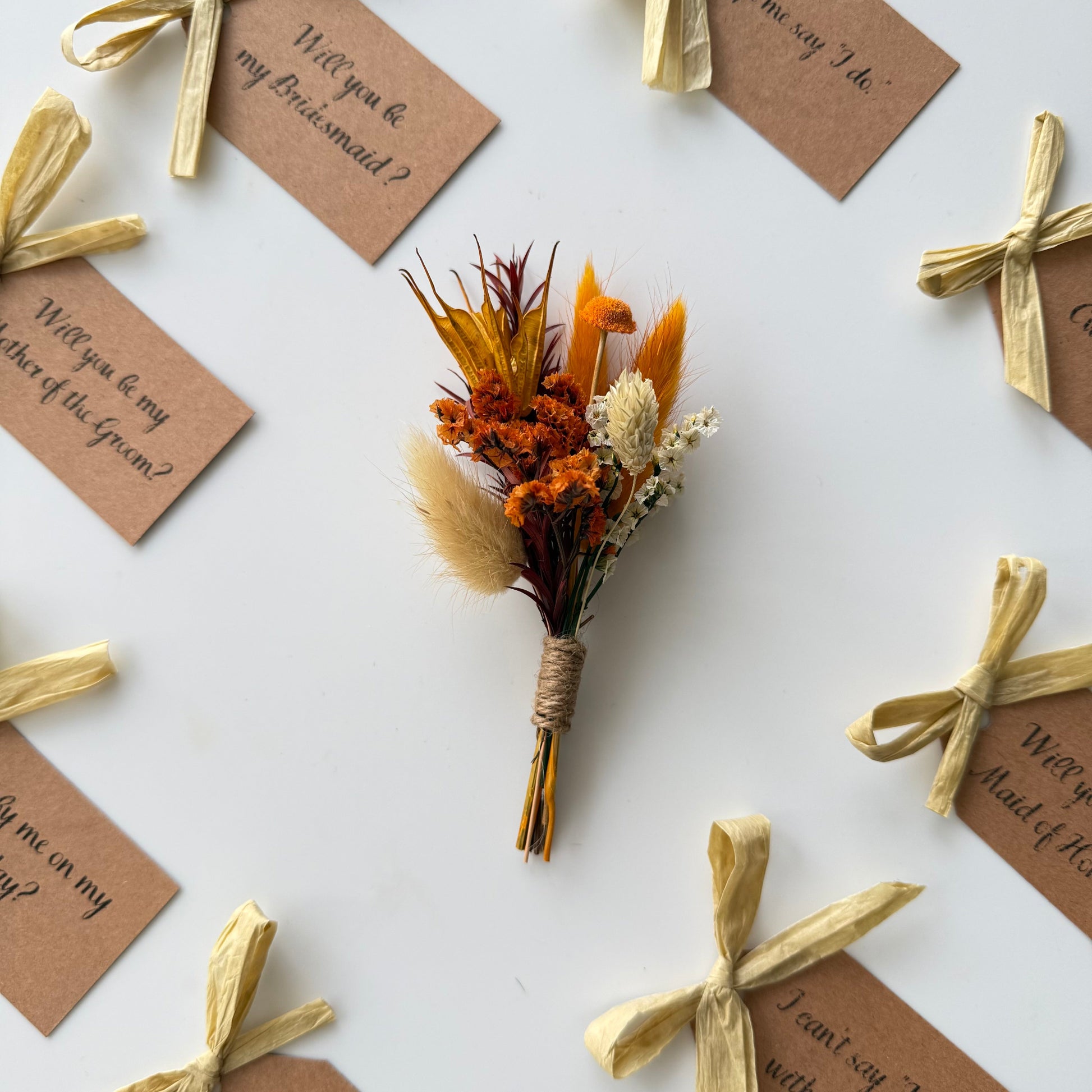 Dried flower bouquet with tied ribbons and question tags on a white background