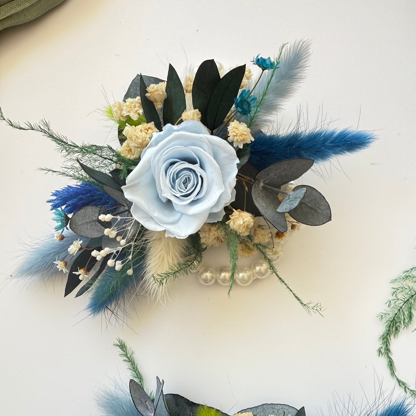 Floral corsage with blue and white flowers on a light background