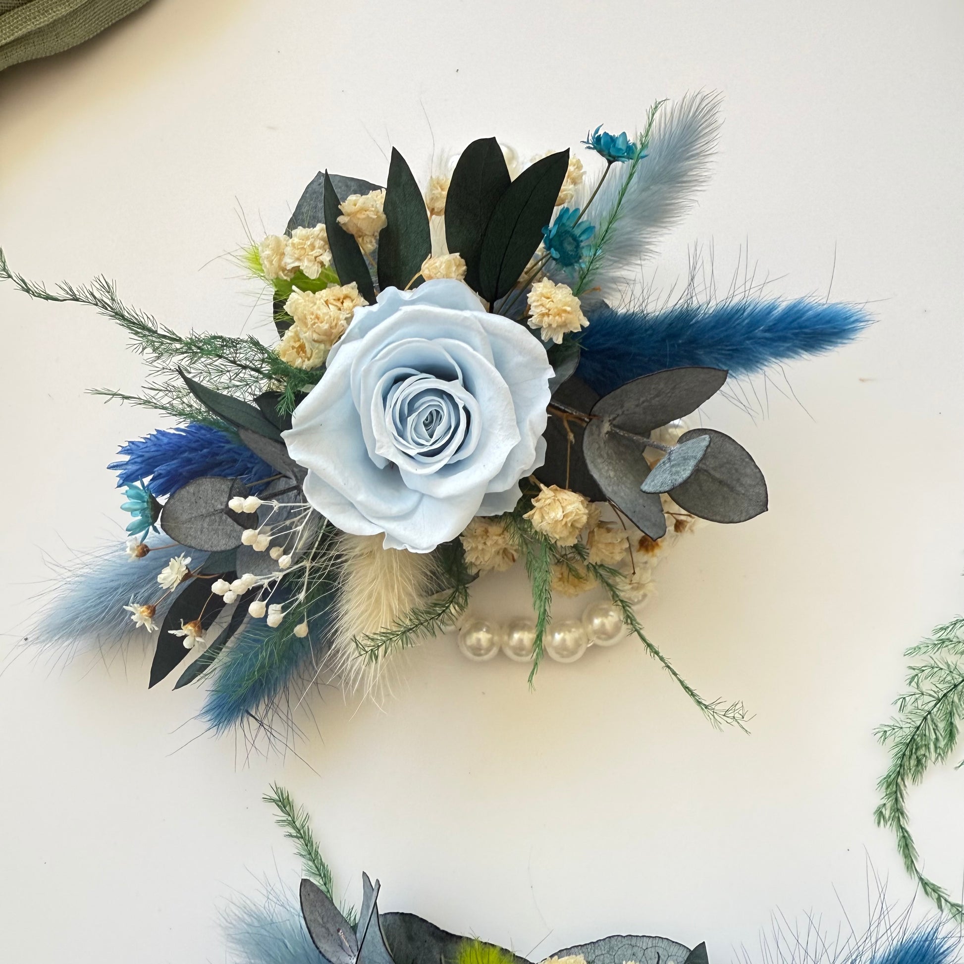 Floral corsage with blue and white flowers on a light background