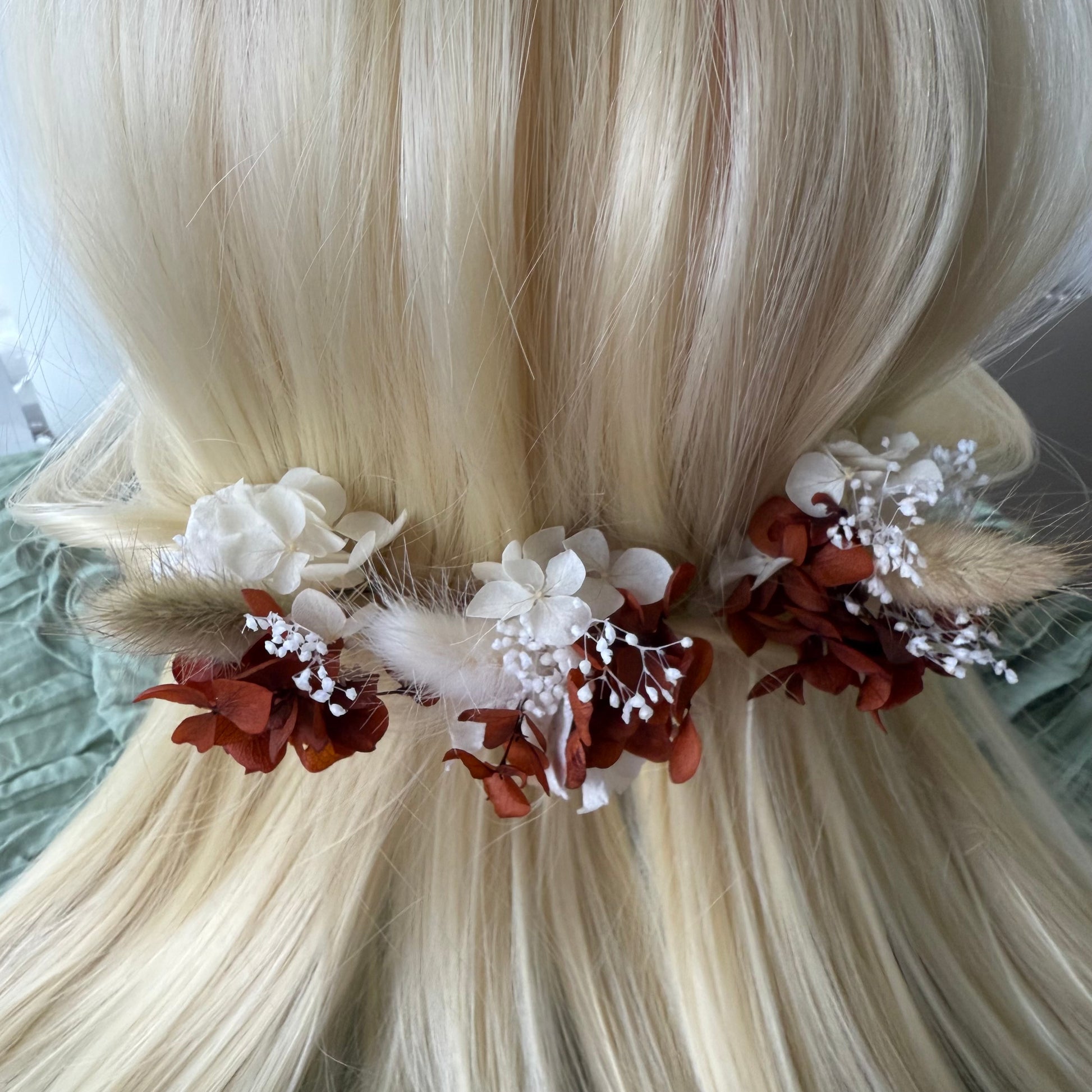 Floral hair accessory with white and brown flowers on blonde hair