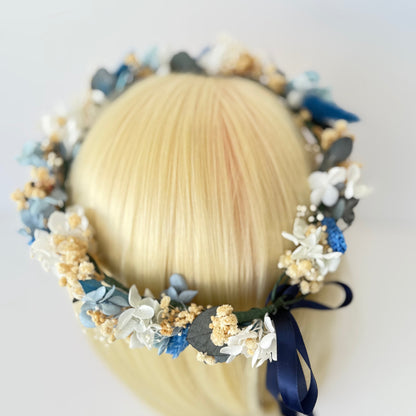 Floral headband with blue and white flowers on a mannequin head against a white background