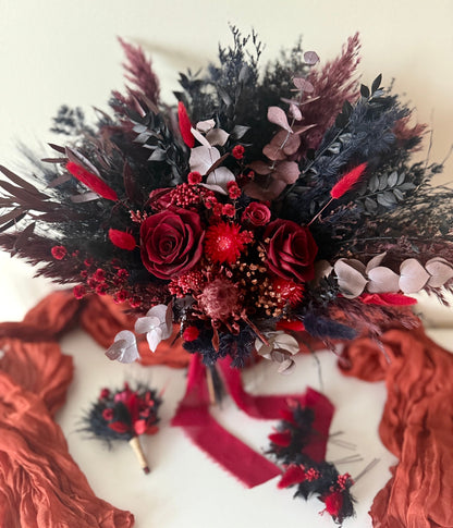 Bouquet of red and black flowers with ribbons on a white background