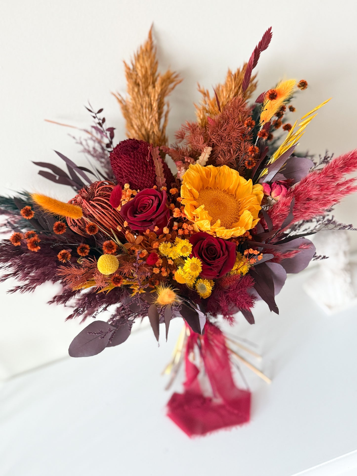 Boho dried wedding bouquet in burgundy tones with wheat and preserved florals