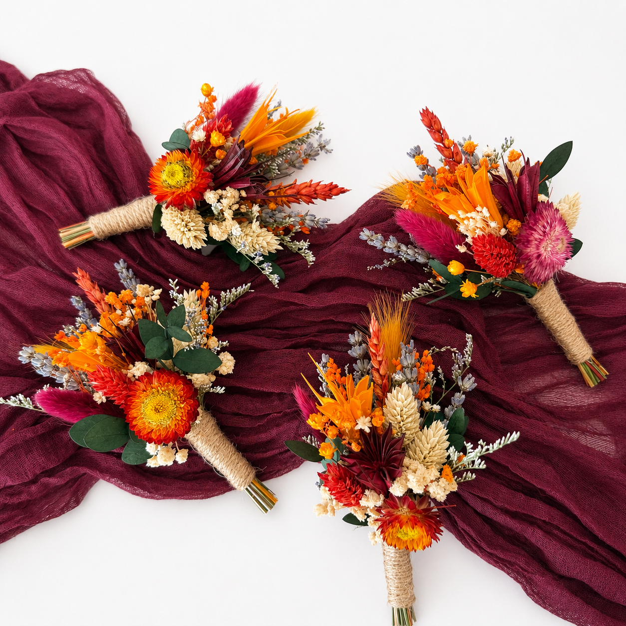 Matching dried flower boutonnières in burnt orange, burgundy and ivory designed to coordinate with the autumn wedding bouquet collection.