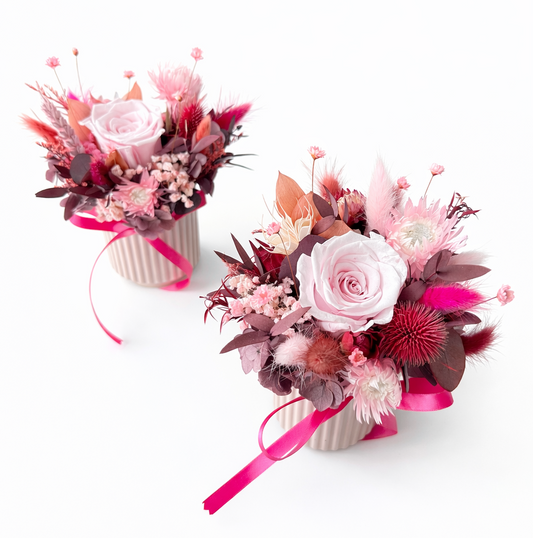 Two floral cups with pink and red flowers on a white background