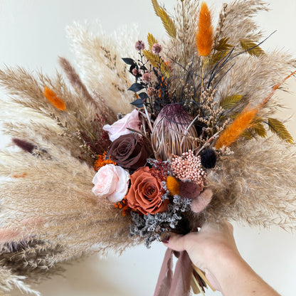 Dark terracotta boho bridal bouquet with preserved roses and pampas grass.