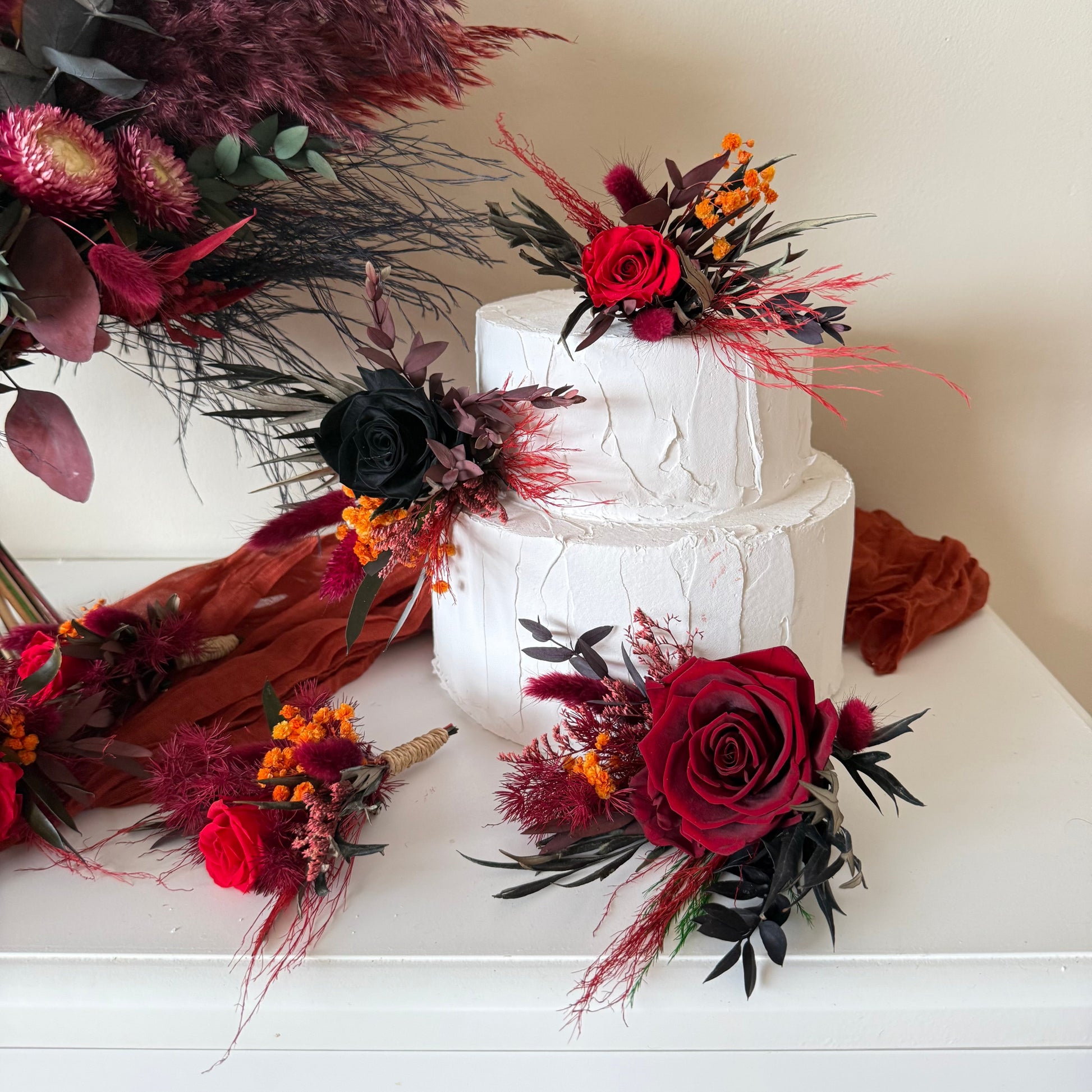Gothic style wedding cake flowers with burgundy roses and dark foliage arrangement