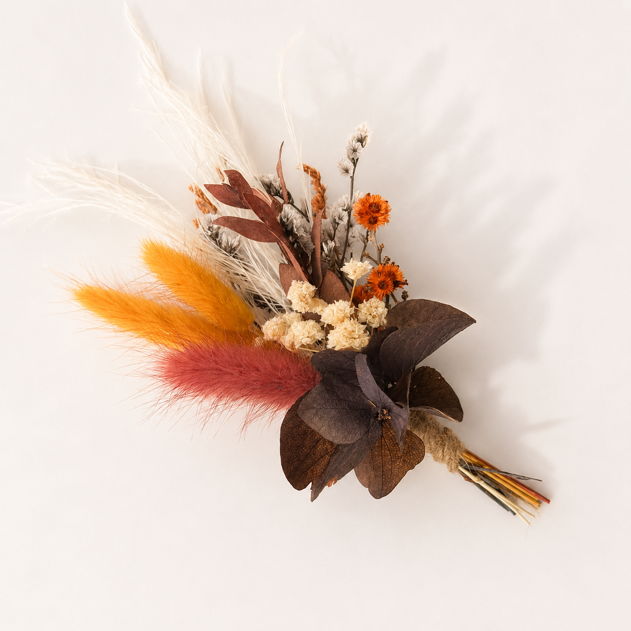 Mini dried flower bouquet with burgundy, rust and ivory preserved flowers in a romantic boho wedding style