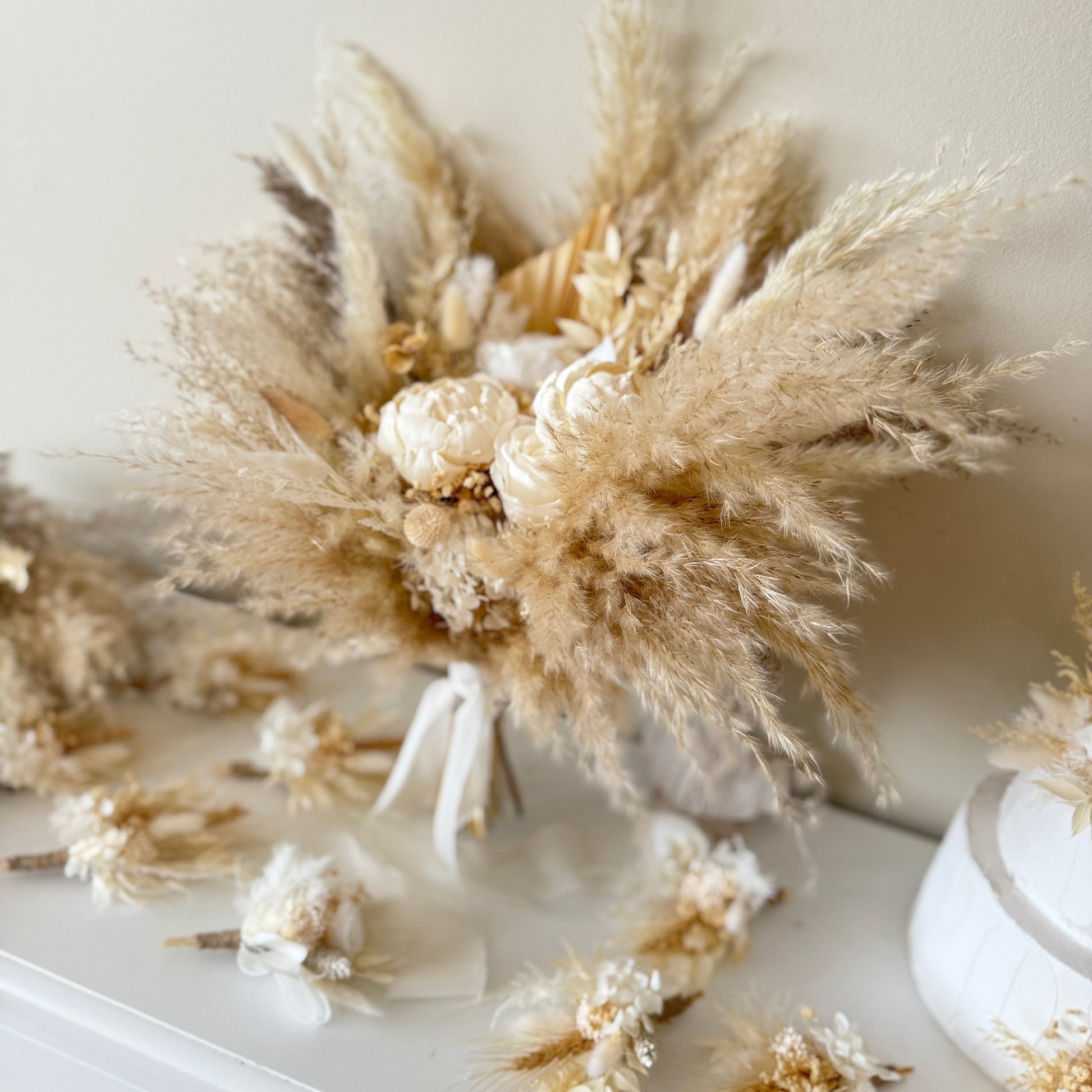 Neutral dried Bridesmaids bouquet with pampas grass and sola peonies, styled as a refined floral display.