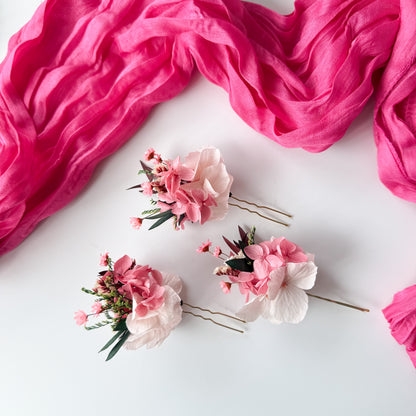 Floral hairpins on a white surface with pink fabric
