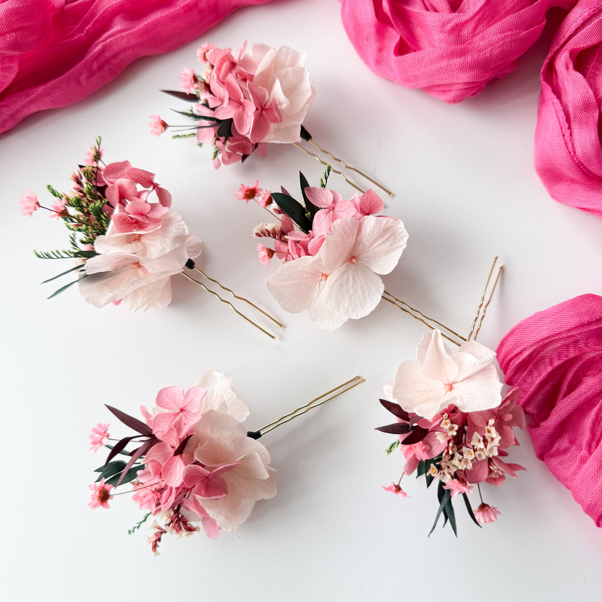 Floral hairpins on a white background with pink fabric
