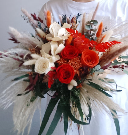 Handheld bridal bouquet with red and ivory preserved roses, pampas grass, bunny tails, and eucalyptus for a bold boho wedding look.

