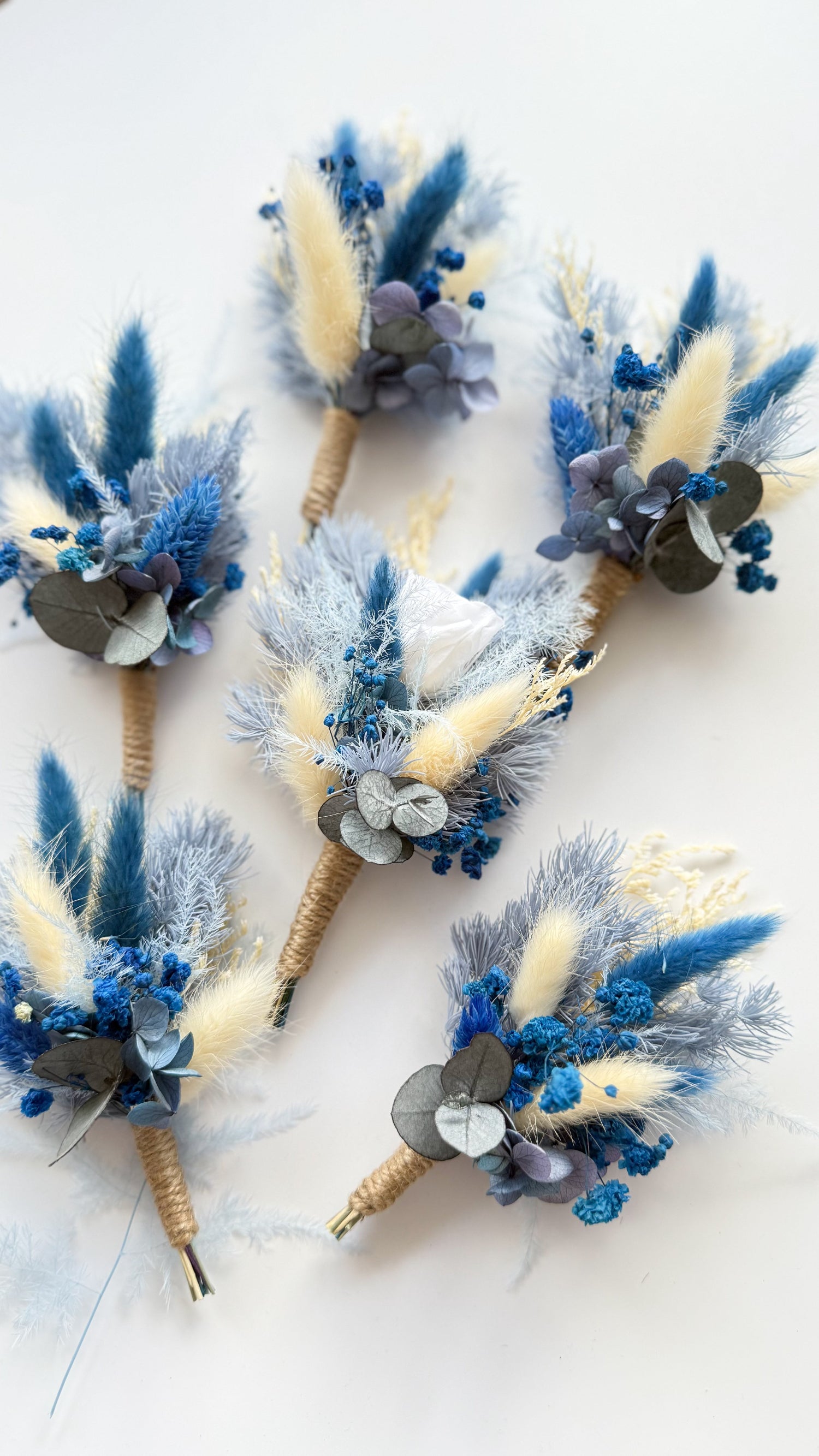 Decorative wreaths with blue and beige flowers on a white background
