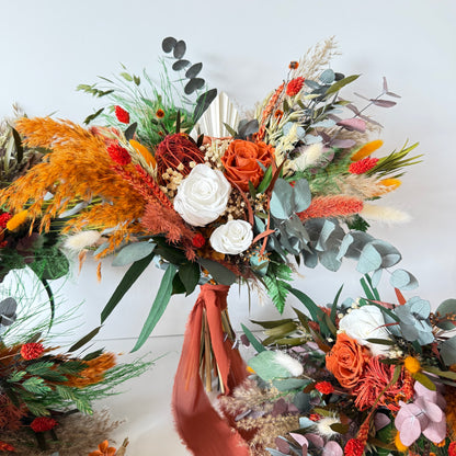 Dried bridesmaid bouquets in warm burnt orange tones with preserved roses, eucalyptus, pampas and natural textures for rustic weddings