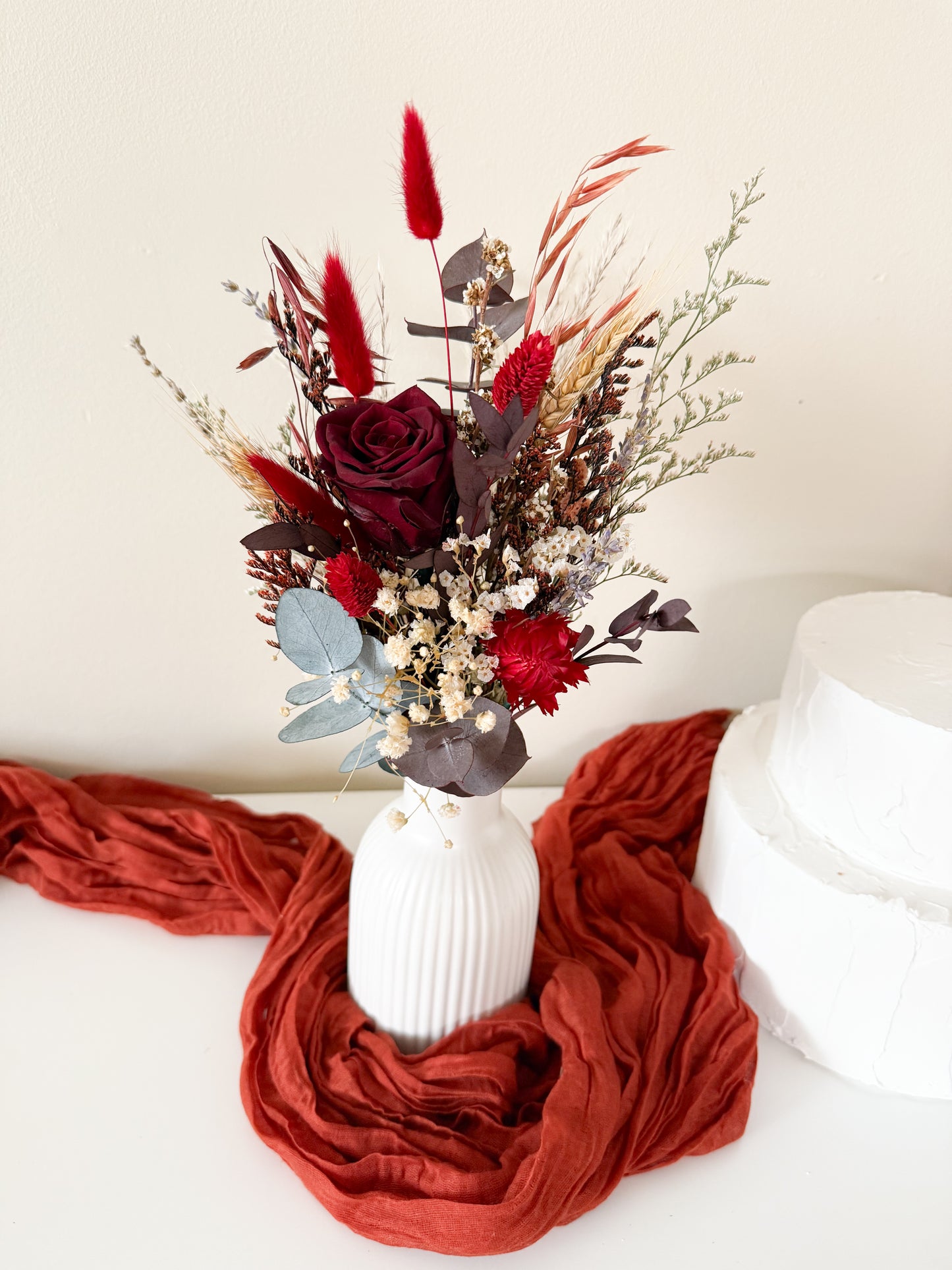 Rustic boho dried floral vases with burgundy sola wood flowers and eucalyptus displayed wall – perfect for Australian wedding decoration