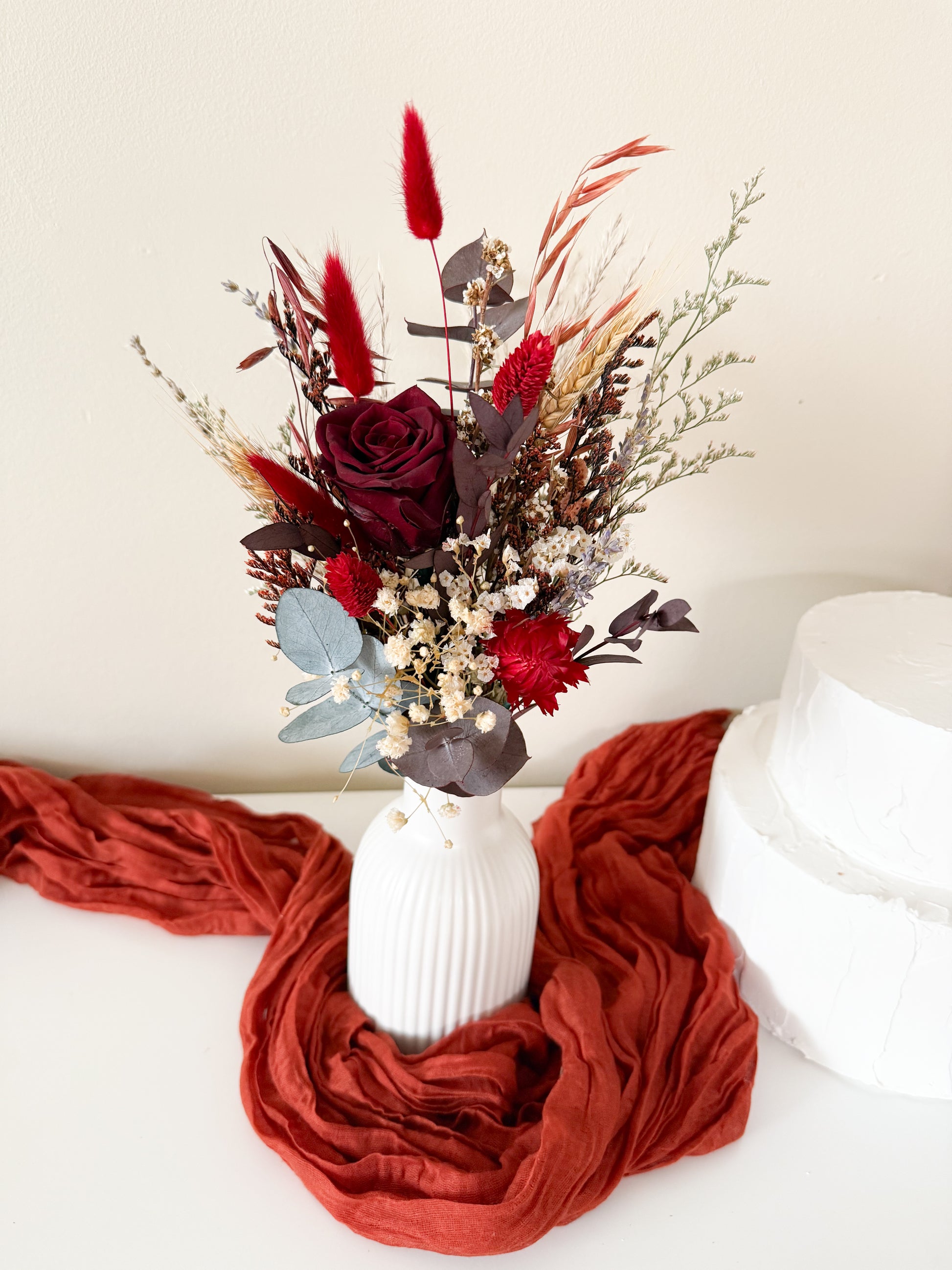 Rustic boho dried floral vases with burgundy sola wood flowers and eucalyptus displayed wall – perfect for Australian wedding decoration