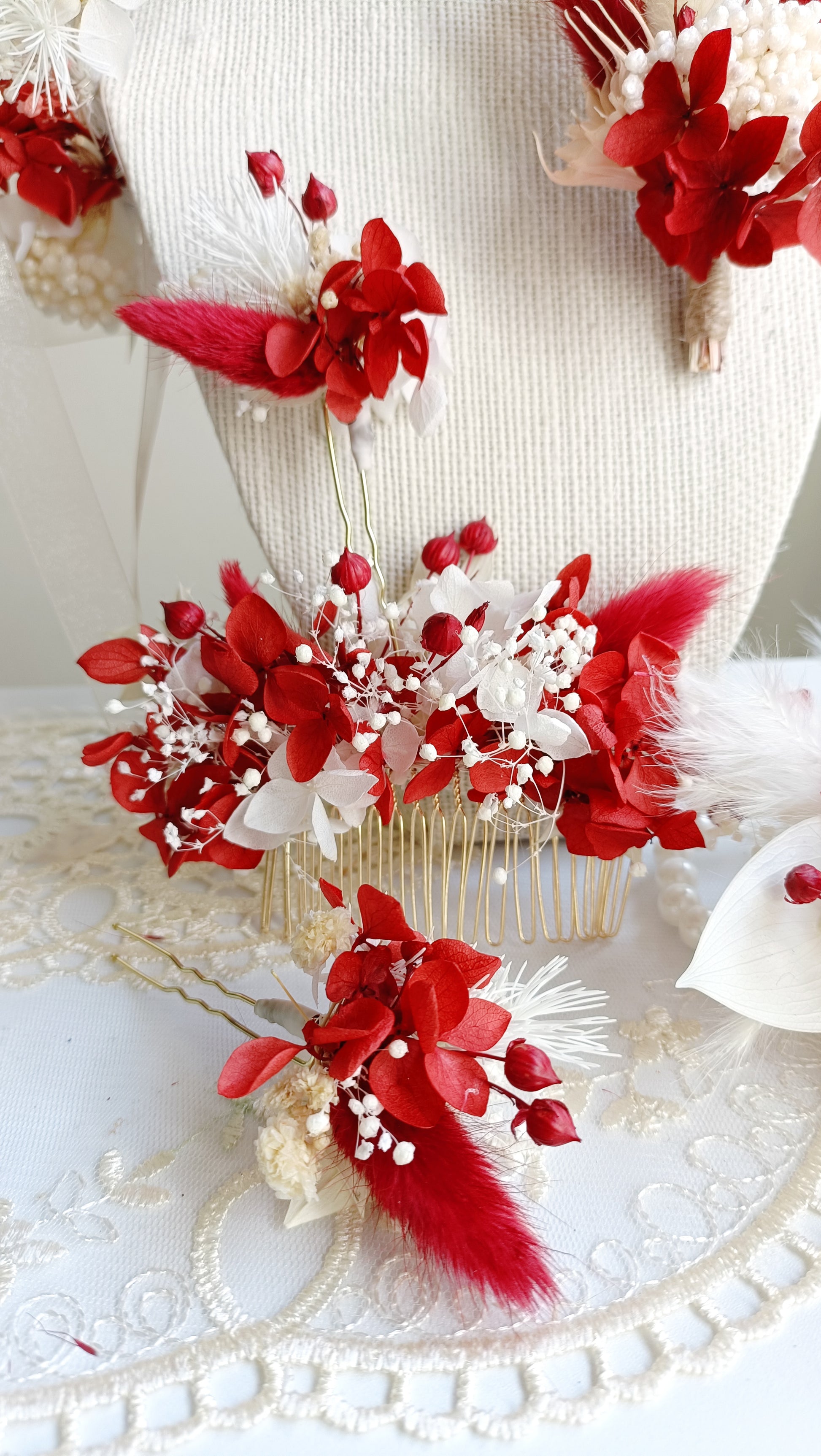 A set of two handcrafted hair clips made from preserved red and white flowers. The clips are detailed with delicate pearl clusters and accented with natural textures for a bohemian feel.