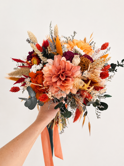 Side view of a preserved bridal bouquet featuring burnt orange dahlia, burgundy flowers, ivory accents and eucalyptus.
