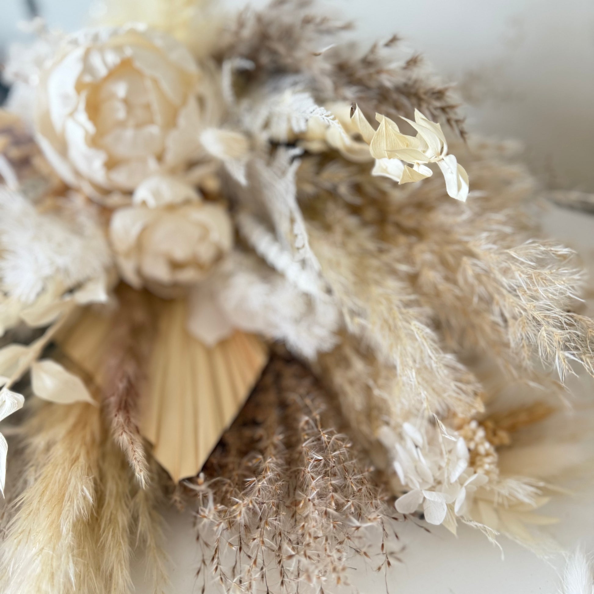 Bridesmaids arrangement with sola peonies and pampas grass, designed as a statement piece for neutral wedding decor.