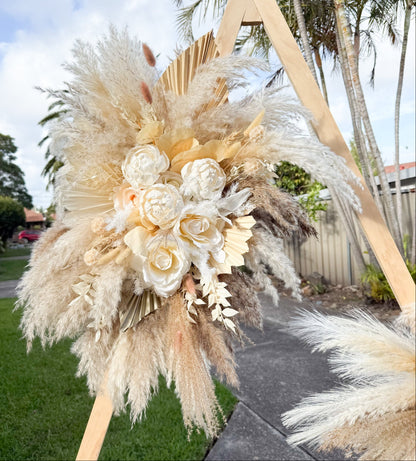 Wedding ceremony backdrop with pampas grass and sola peonies, styled in neutral tones for elegant outdoor celebrations.