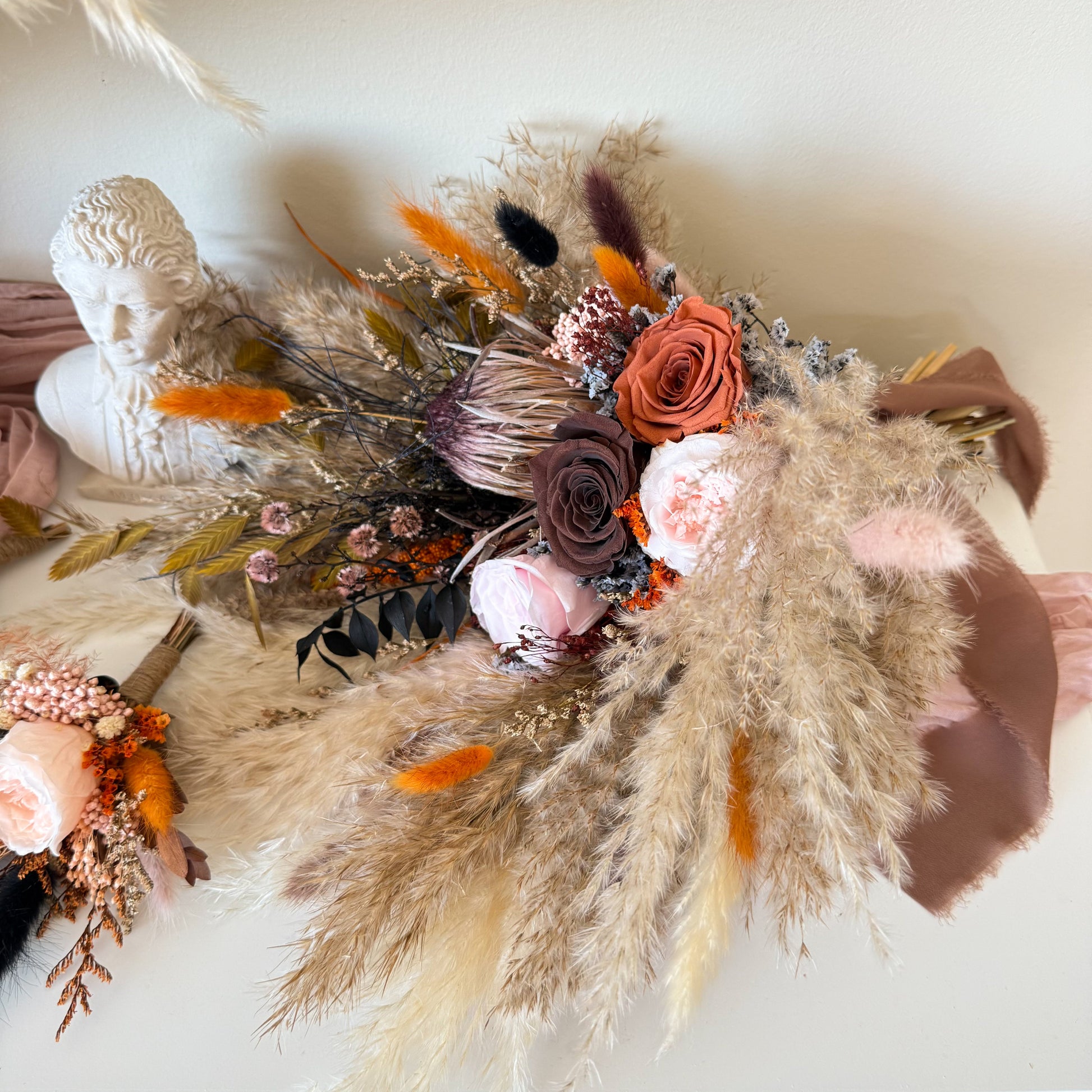 Terracotta and blush preserved rose bouquet with dried grasses and boho textures.