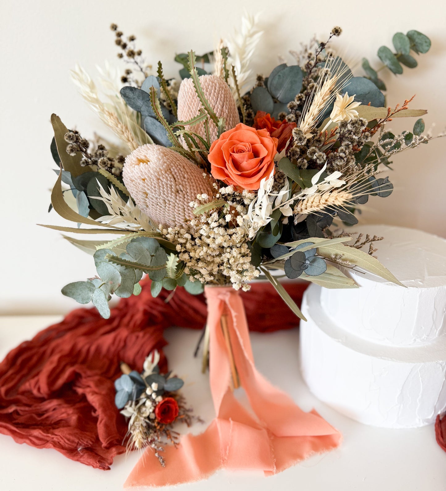 Rustic dried flower bouquet with preserved terracotta rose, banksia, eucalyptus and native greenery, boho wedding flowers.