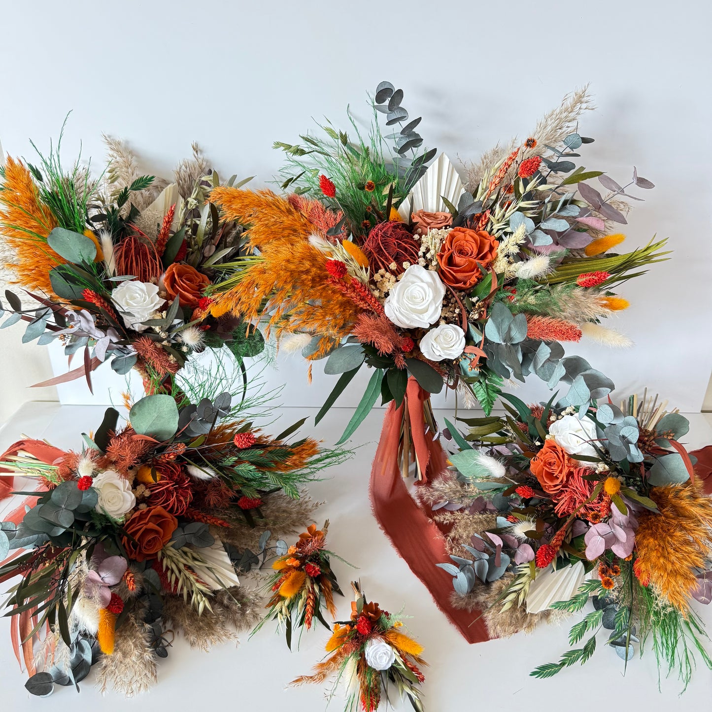 Close-up of a dried terracotta wedding bouquet featuring preserved roses, eucalyptus, bunny tails and burnt orange accents
