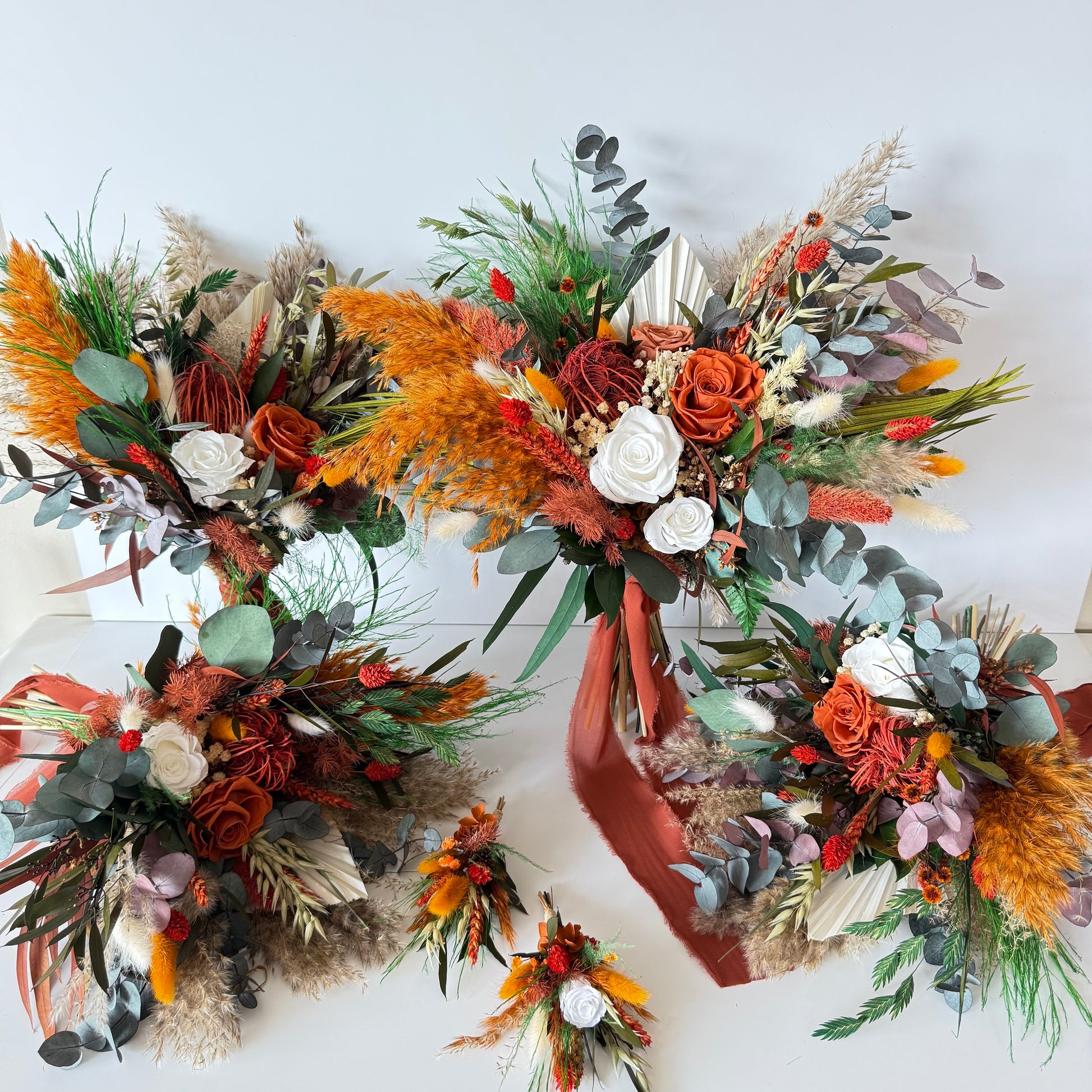 Close-up of a dried terracotta wedding bouquet featuring preserved roses, eucalyptus, bunny tails and burnt orange accents
