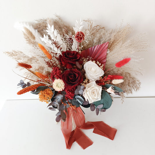 Terracotta dried bridal bouquet with burgundy roses, white preserved flowers, and pampas grass – front view

