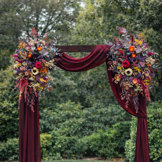  arch flowers and burgundy fabric in an outdoor setting
