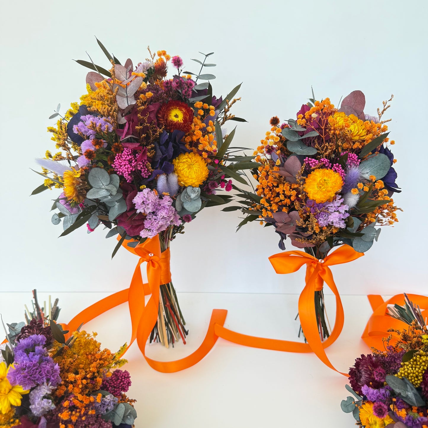 Bouquets of flowers with orange ribbons on a white background