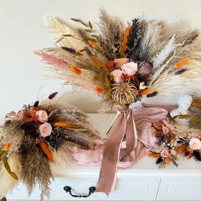 Styled wedding bouquet scene with blush fabric and matching dried flower accessories.