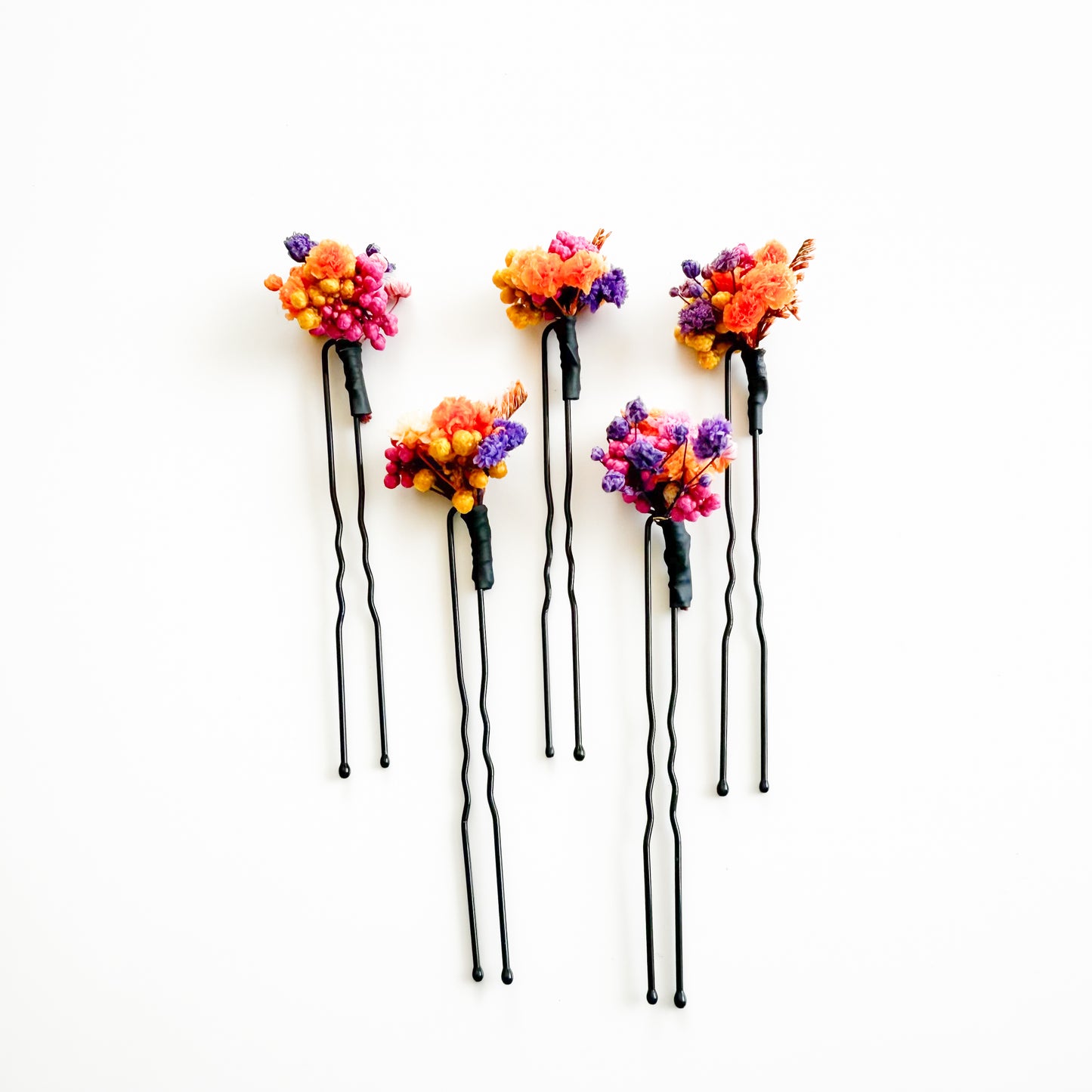 Five floral hairpins with colorful flowers on a white background
