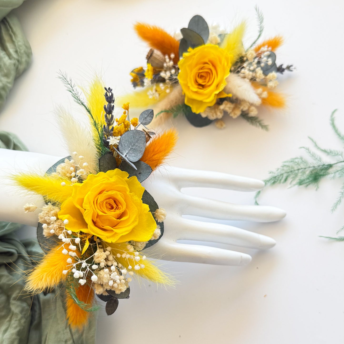 Yellow flower corsages on white gloves with green fabric background