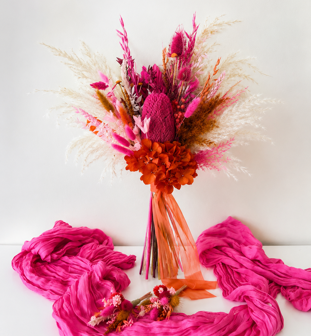 Australian Native Hot Pink Banksia Bridesmaid Bouquet with preserved hydrangea, pampas grass and dried flowers in magenta, pink and burnt orange tones for colourful boho weddings.